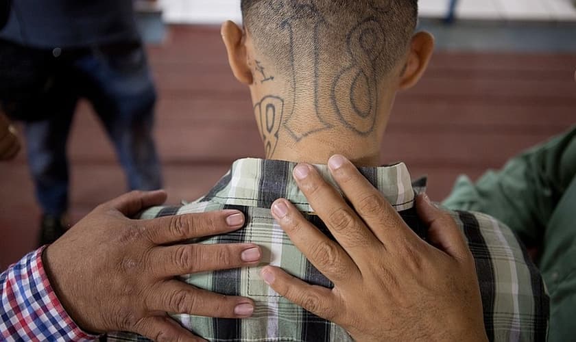 José Rolando Arévalo, 24 anos, ex-membro de uma gangue, recebe oração de pastores. (Foto: Alicia Vera)