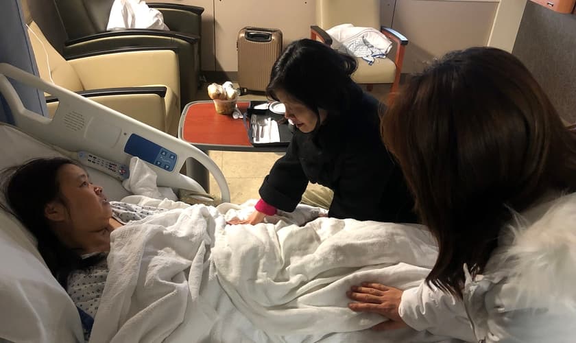 Peggy Lee (centro) e Ginny Won oram por um dos 50 passageiros feridos no acidente em Richmond. (Foto: Grace Chinese Baptist Church)