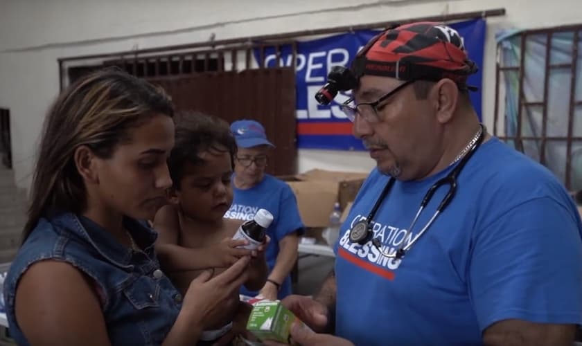 Missionário presta atendimento médico a Izana e seu filho Wilson. (Imagem: CBN News)