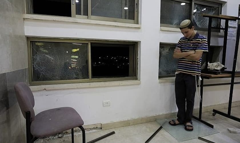 Um dos estudantes que estava dentro de uma escola religiosa judaica em Sderot, Israel, depois de ter sido atingido por um foguete lançado da Faixa de Gaza, quinta-feira, 13 de junho de 2019. (Foto: Tsafrir Abayov/AP)