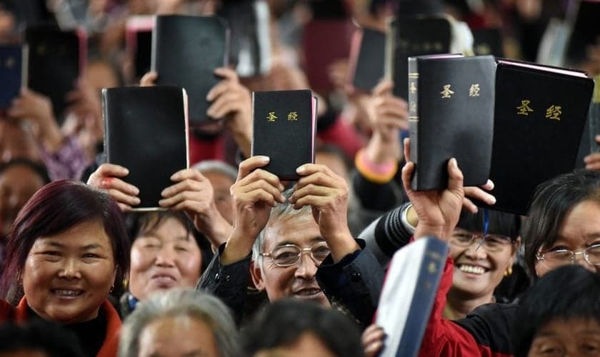 Cristãos Chineses mostram suas Bíblias em culto. (Foto: Bible Society - Australia)