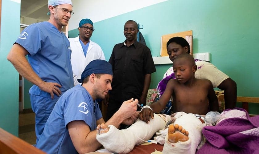 Médicos cuidam de Amié, de 9 anos, depois de uma cirurgia extensa em suas pernas. (Foto: David K. Morrison/Samaritan's Purse)
