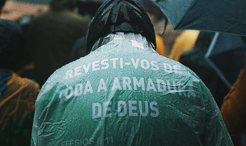 Em Porto Alegre, homem usa capa com versículo bíblico durante ato. (Foto: Matheus Bazzo)