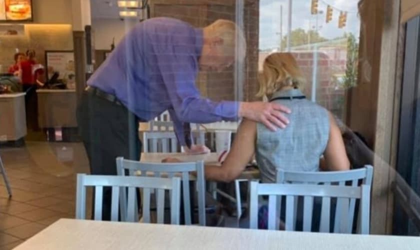 O funcionário da Chick-fil-A, Stephen Spray, ora por cliente. (Foto: Reprodução/Brittany Calden)