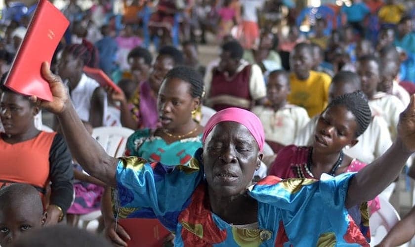 Mulher segura o Novo Testamento escrito em Lugwere pela primeira vez. (Foto: Reprodução/Wycliffe Bible Translators)