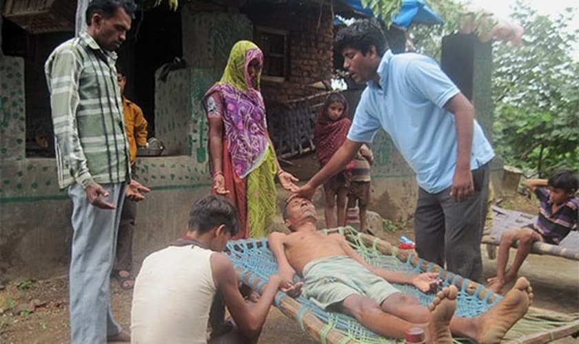 O pastor Haatim ora por cura de um homem afligido pela doença. (Foto: Reprodução/GFA)