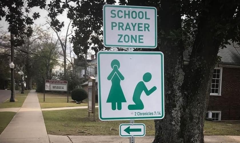 Placas com versículo bíblico convidam pais e alunos à oração. (Foto: Reprodução/CBN News)