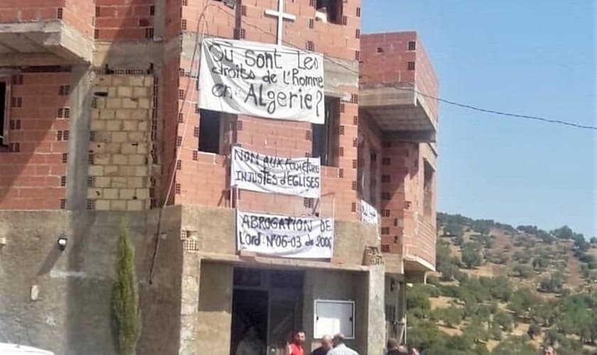Cristãos impedem fechamento de igreja com cartazes e oração. (Foto: Reprodução/Morning Star)