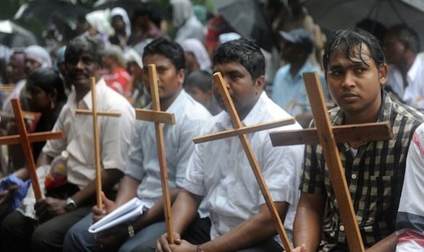 Cristãos seguram cruzes como símbolo de sua fé. (Foto: Reprodução/AFP)