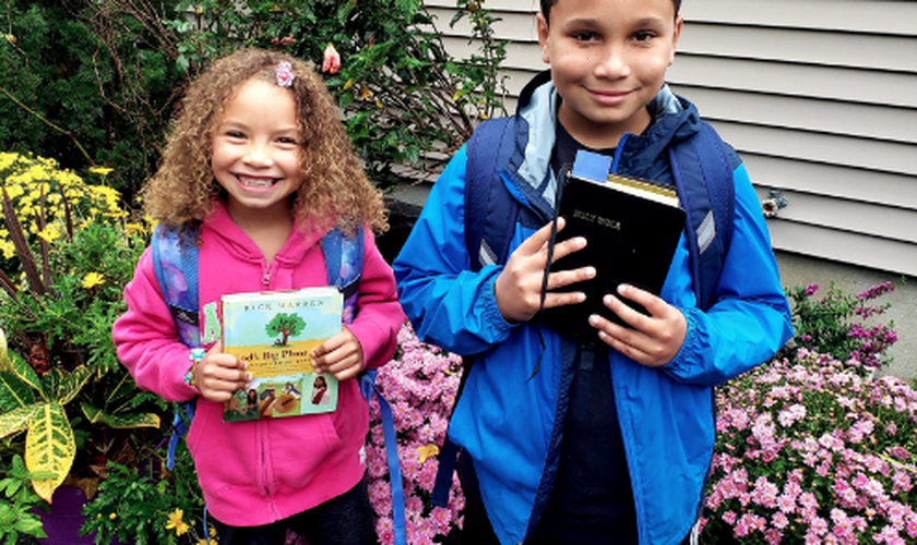 Alunos do condado de Suffolk, em Nova York, fotografam suas Bíblias antes de levá-las para a escola. (Foto: CBN News)