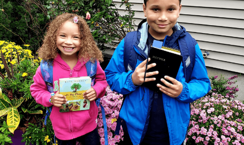 Alunos do condado de Suffolk, em Nova York, fotografam suas Bíblias antes de levá-las para a escola. (Foto: CBN News)