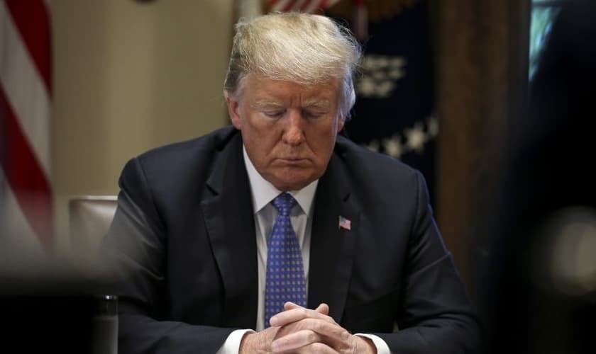 Trump ora em seu gabinete, na Casa Branca. (Foto: EAWorldView)