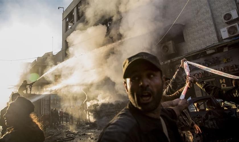 Bombeiros combatem chamas após explosão de carro-bomba na cidade de Qamishli, na Síria. (Foto: Baderkhan Ahmad/AP)