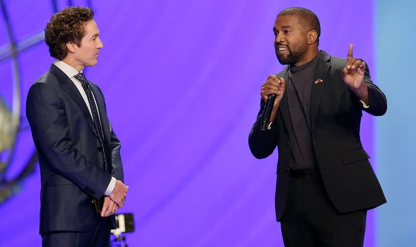 Kanye West ao lado do pastor Joel Osteen (à esquerda), durante um culto na Igreja Lakewood. (Foto: AP/Michael Wyke)