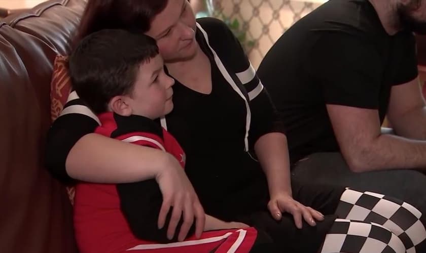 Noah Woods é abraçado pela mãe, após salvar sua família de um incêndio. (Foto: ABC News)