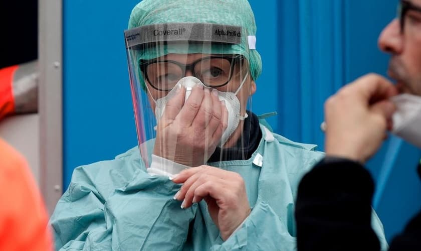 Profissional de saúde se prepara enquanto recebe recomendações para atendimento de infectados na Itália. (Foto: AP Photo)