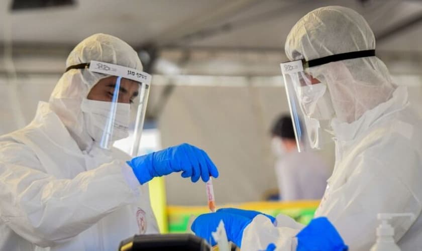 Médicos manuseiam uma amostra de teste de coronavírus em Tel Aviv. (Foto: Flash90)