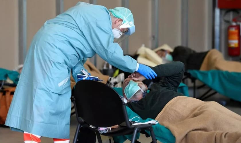 Equipe médica ajuda pacientes dentro do hospital Spedali Civili em Brescia, na Itália. (Foto: Flavio Lo Salzo/Reuters)