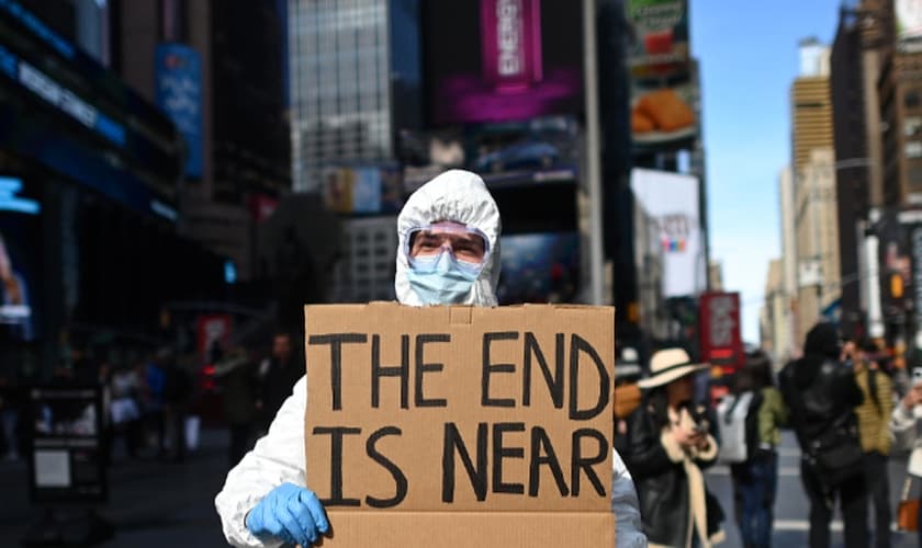 "O fim está próximo", diz manifestante em cartaz sobre coronavírus na Times Square, em Nova York. (Foto: Johannes Eisele/AFP)