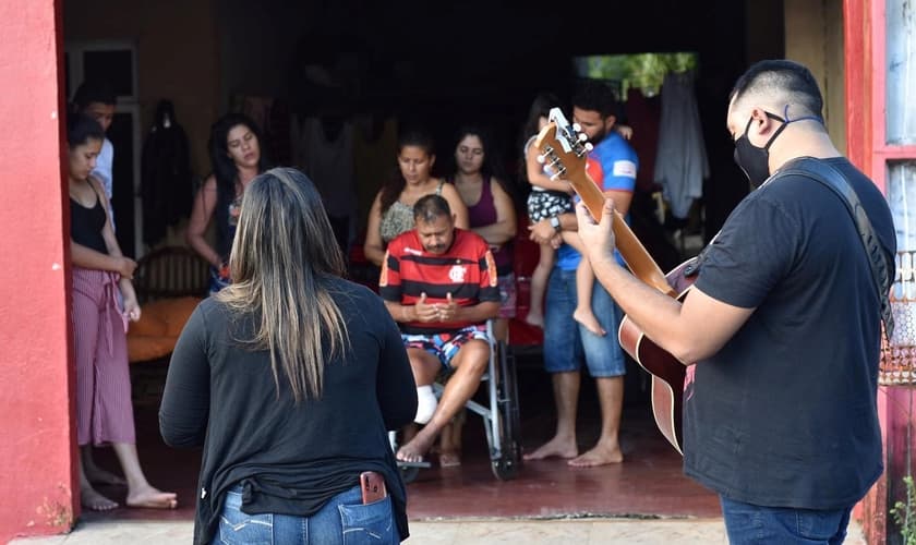 Fiéis recebem oração e louvor na porta de suas casas. (Foto: Reprodução/Facebook)