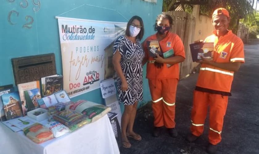 A mesa solidária despertou a atenção de dois profissionais de limpeza urbana que quiseram pegar livros religiosos. (Foto: Arquivo pessoal)