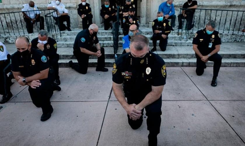 Policiais se ajoelharam durante um comício em Coral Gables, Flórida, no sábado, em resposta à morte de George Flay. (Foto: Eva Marie Uzcategui / AFP via Getty Images)