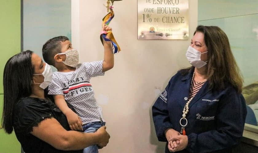 Brener Lorenzo, de 4 anos, toca o sino da cura após dois anos e meio de tratamento. (Foto: Governo do Amazonas)