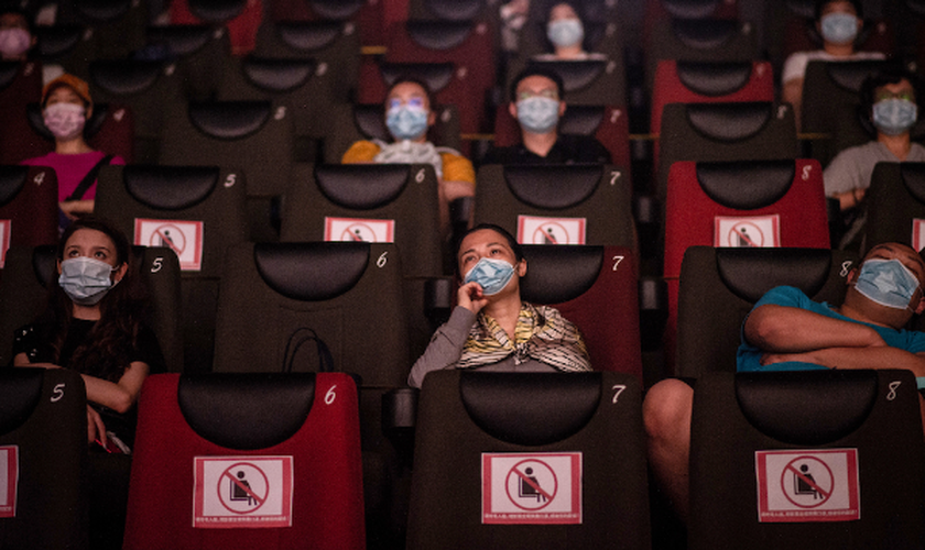 As pessoas assistem a um filme no dia 20 de julho, no primeiro dia da reabertura dos cinemas chineses em Wuhan, na província de Hubei. (Foto: Reprodução / AFP)
