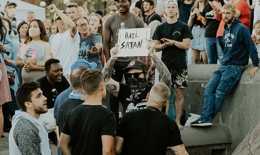 Homem segura placa com a frase “Salve Satanás” em meio a cristãos em Seattle. (Foto: Instagram/Sean Feucht)