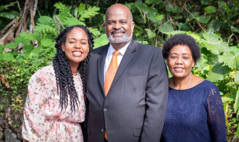 Pastor Eli Henry (ao centro), com sua esposa (à esquerda) e sua filha, Irma (à direita). (Foto: IASD News)