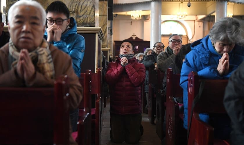Cristãos chineses participam de momento de adoração em igreja de Pequim. (Foto: Greg Baker/AFP via Getty Images)