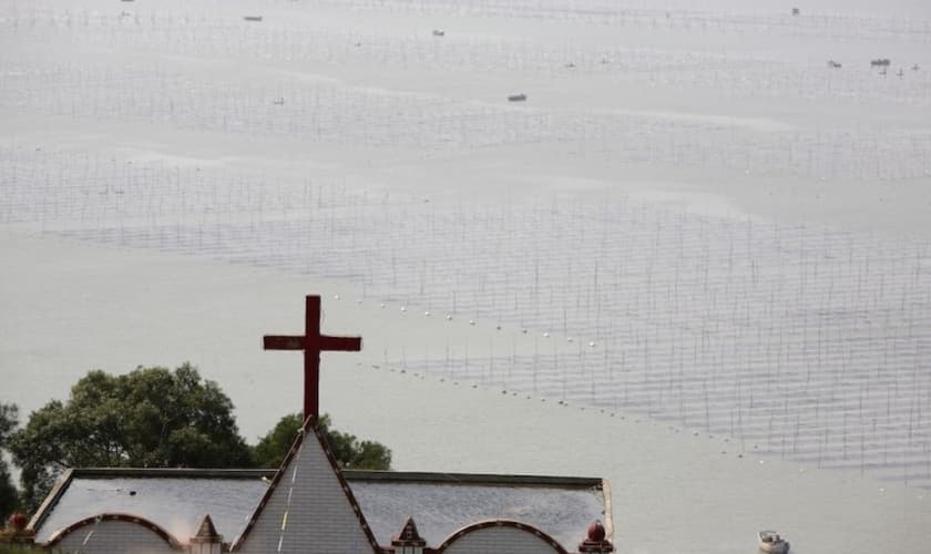 Uma igreja é vista ao lado de uma fazenda de lavatório na vila de Gutong, no município de Sansha, no condado de Xiapu, na província de Fujian, China. (Foto: Getty Images/China Photos)