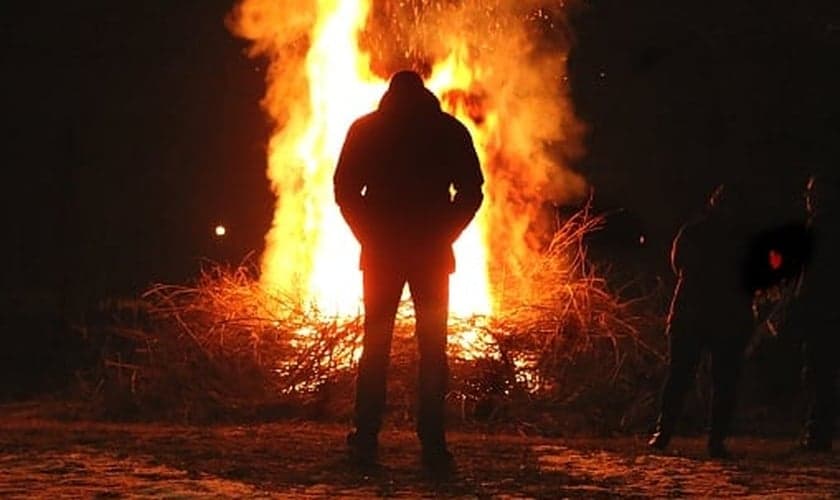 Imagem ilustrativa de homem em frente ao fogo. (Foto: Getty Images/iStockphoto)