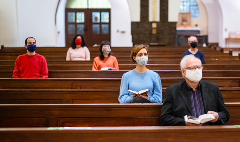 Fiéis em igreja usando máscaras e mantendo distanciamento social. (Foto: Luis Alvarez/Getty Images)