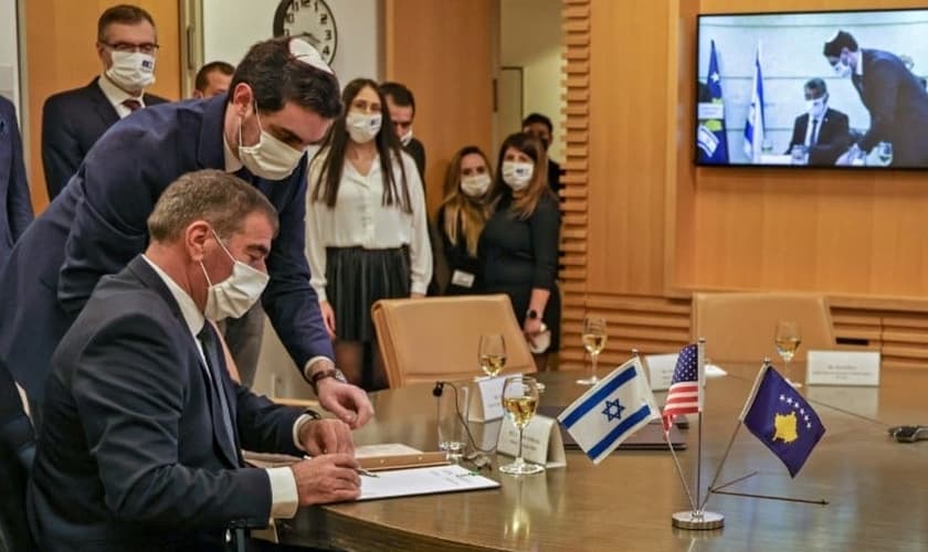 O ministro israelense das Relações Exteriores Gabi Ashkenazi assina documento de normalização das relações diplomáticas com Kosovo. (Foto: Reprodução / AFP)