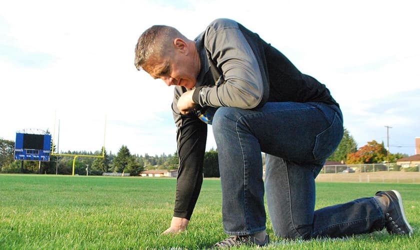 O treinador Joe Kennedy orando no campo. (Foto: Reprodução / First Liberty)