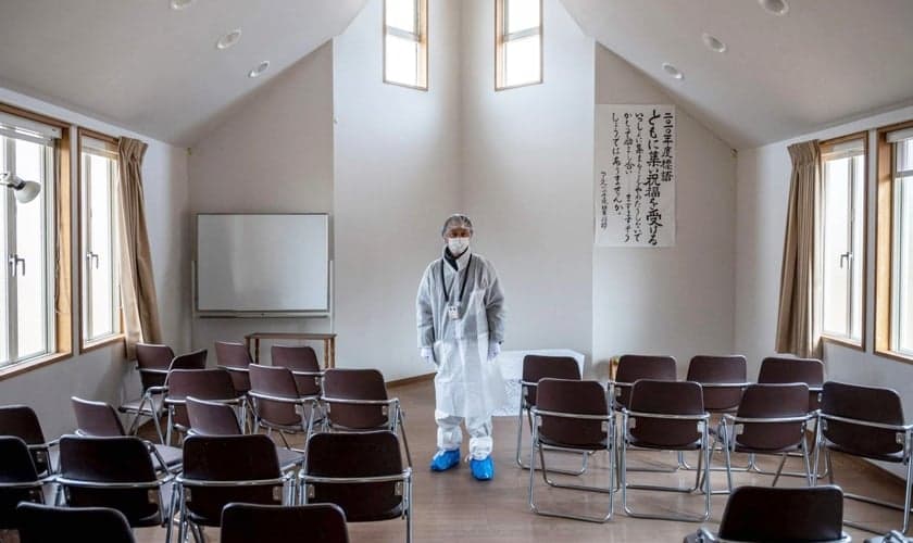 Reverendo Akira Sato usa traje de proteção no templo abandonado da antiga Primeira Igreja Batista Bíblica de Fukushima. (Foto: AFP)