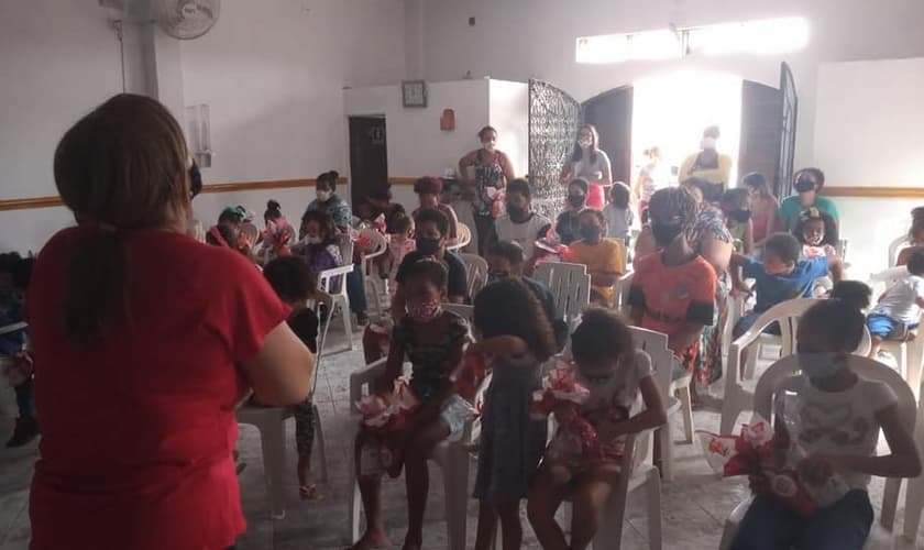 A diretora Dilene Santos ora com as crianças do Projeto Kids Crescer e Vencer. (Foto: Reprodução / Facebook)