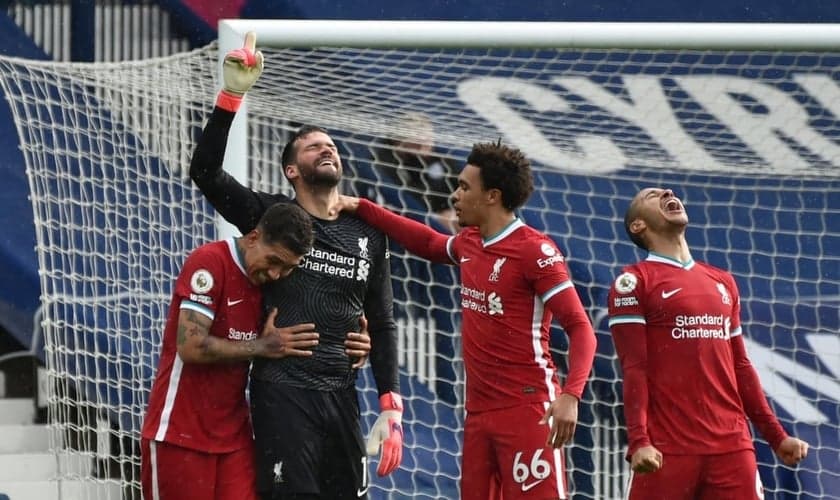 Alisson Becker, goleiro do Liverpool, aponta para o céu após surpreendente vitória. (Foto: Rui Vieira/Reuters)