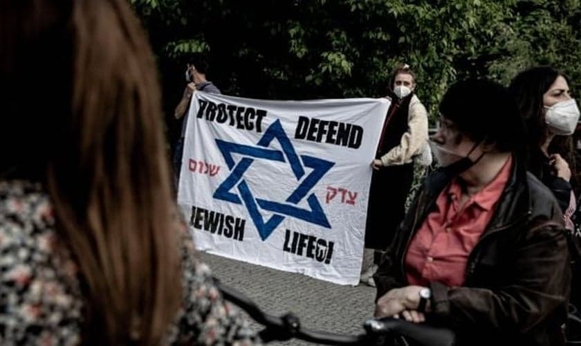 Participantes de uma vigília contra o antissemitismo se reúnem em frente à sinagoga em Kreuzberg, Berlim, no domingo. (Foto: Filip Singer / EPA)