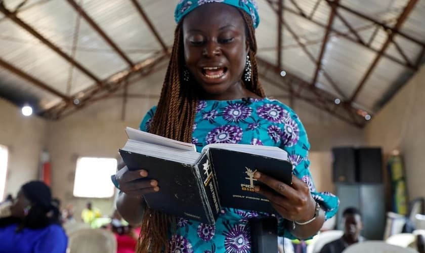 Mulher e a Bíblia Pidgin durante culto na Igreja do Cidadão Celestial em Lagos, Nigéria. (Foto: Reuters / Temilade Adelaja)