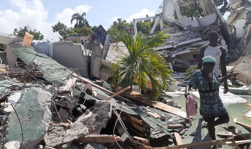 Pessoas caminham entre escombros de casas destruídas pelo terremoto em Les Cayes, no Haiti. (Foto: Jose Flecher/Reuters).