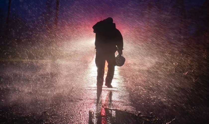 Um chefe de bombeiros voltando para o seu caminhão, na chuva, em Louisiana, depois da passagem do furacão Ida. (Foto: Mark Felix/AFP)