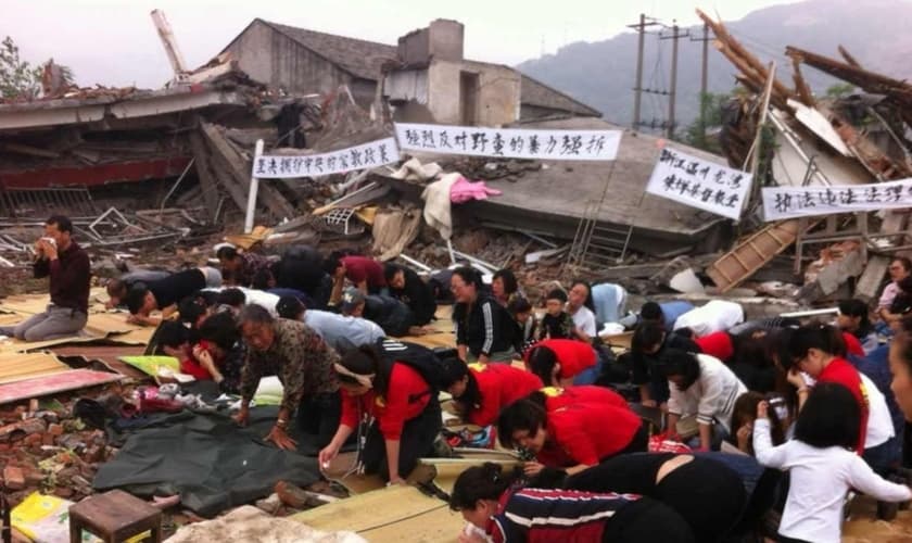 Cristãos se ajoelham nos escombros de uma igreja demolida . (Foto: Reprodução / China Aid)