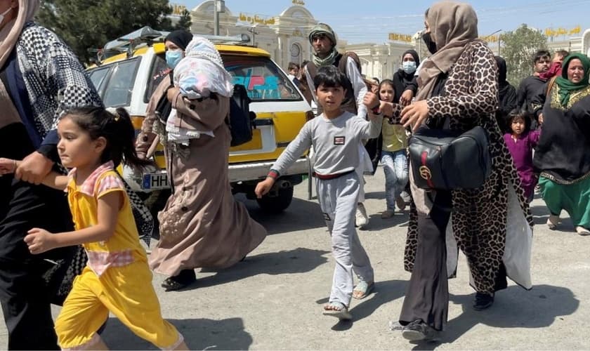 Mães e filhos tentam entrar no aeroporto Hamid Karzai, em Cabul, para fugir do país. (Foto: Reuters)