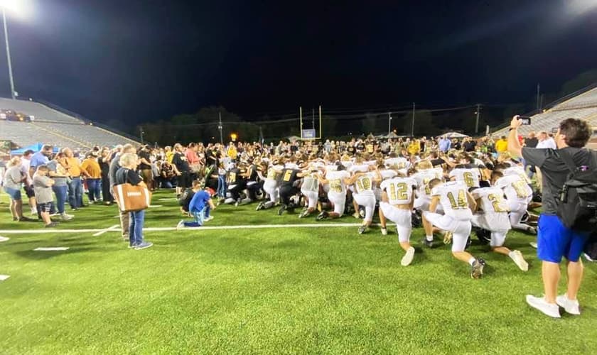 Jogadores de futebol conduzem pais e torcedores em oração após jogo no Condado de Putnam, nos EUA. (Foto: Bob Vick)