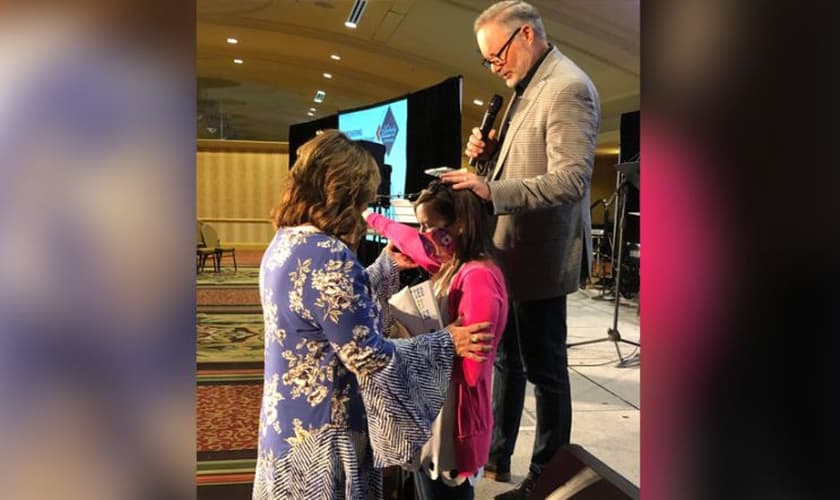 Rita DuBose (à esq.) e seu marido oram por Cassie Fawns durante culto. (Foto: AG News)