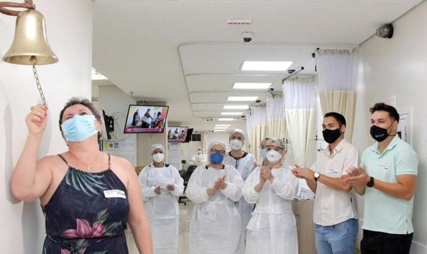 Geane ao tocar o “sino da vitória” por finalizar o processo de quimioterapia. (Foto: Divulgação/Hospital de Base)