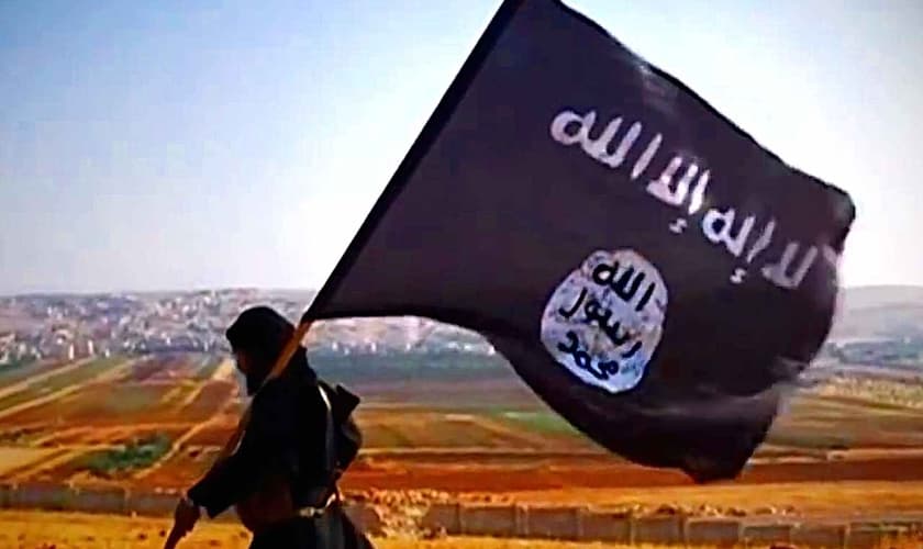 Um militante do Estado Islâmico carregando a bandeira do grupo. (Foto: Wikipedia)