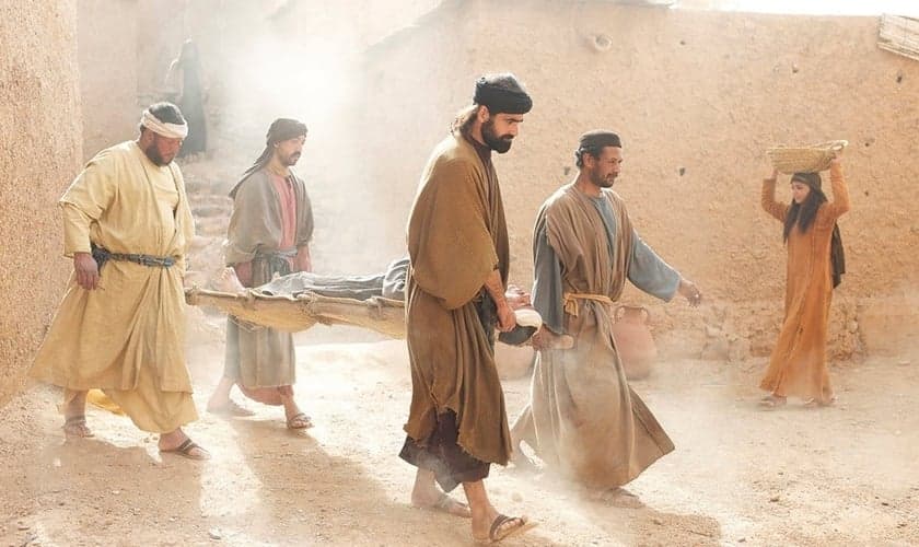Amigos levam paralítico até Jesus para ser curado. (Foto: FreeBible)